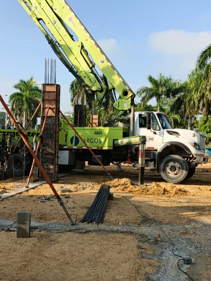 Camión bomba de concreto junto a columnas en construcción en Villa Grande.